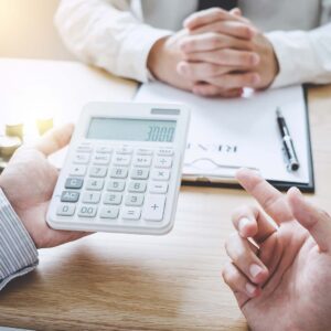 Mortgage officer holding a calculator while talking with a client.